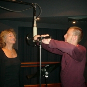 Engineer Chris Brooke adjusts Carole's microphone. Photo by Rudy Guess